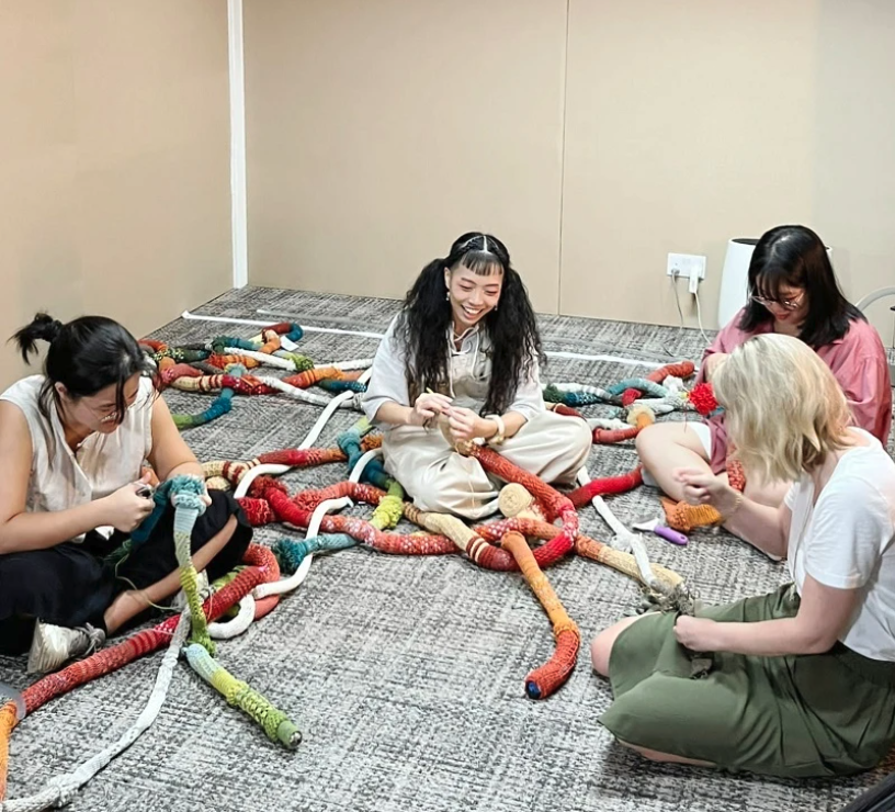 People sitting on the floor working on something together