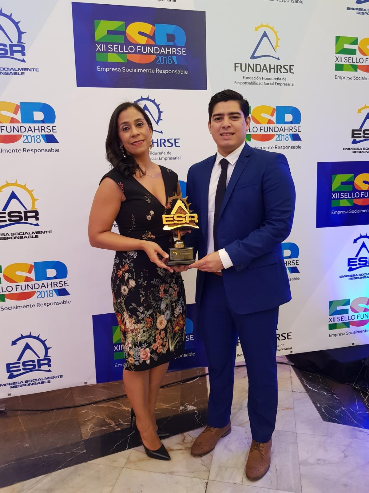 Paola Villaneuva, Communications Manager and Quintin Juarez, Communications Advisor accept the FUNDAHRSE award