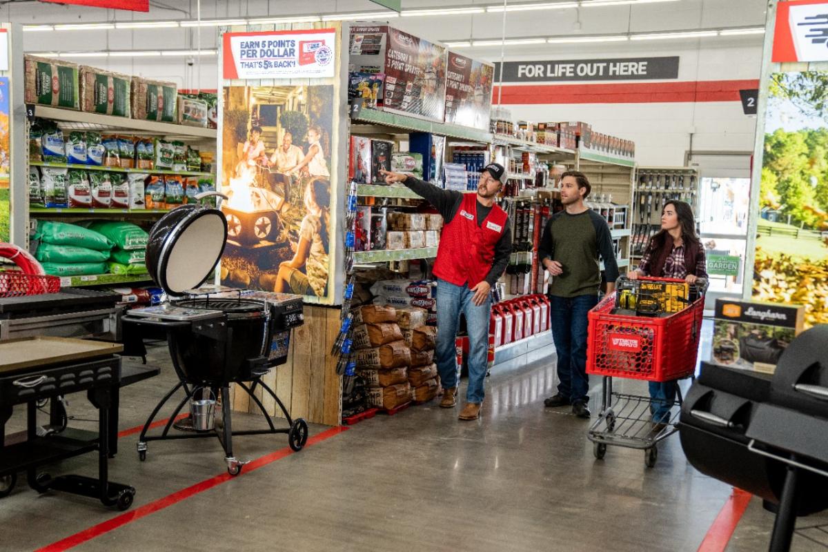 a Tractor Supply employee helping a couple locate an item in store