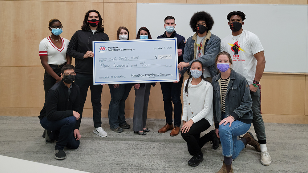 Members of a student organization at University of Utah holding a check from Marathon Petrolium