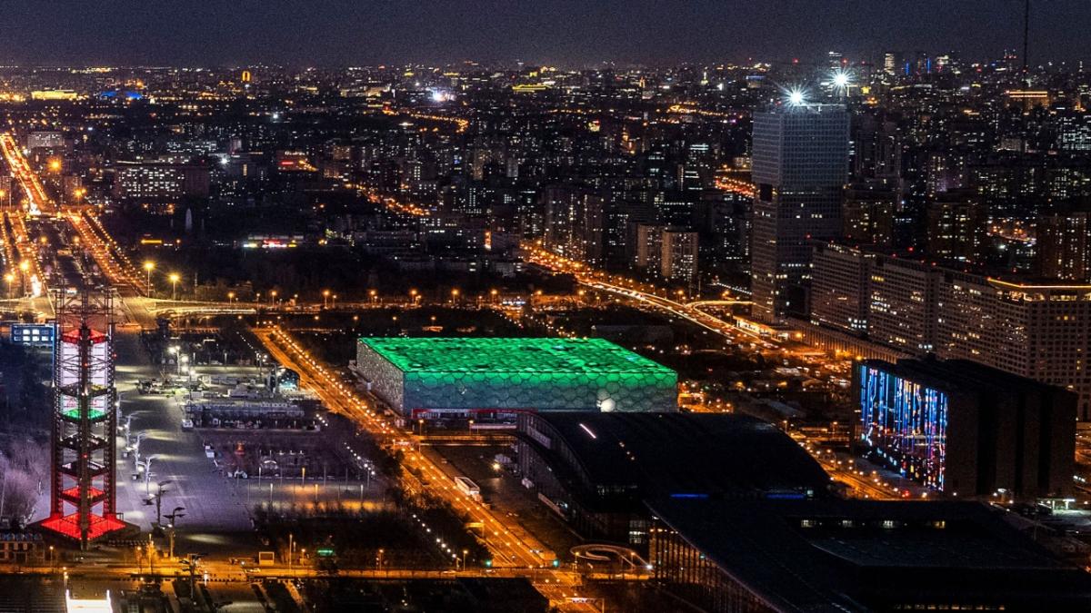 Beijing at night with a building lit in green