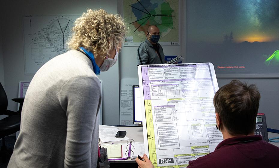 Nicole Flippin looking over a large document with another person