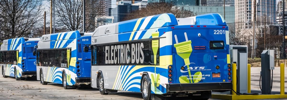 electric buses charging on a city street