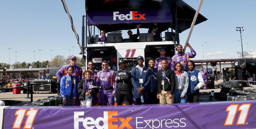 People standing together behind FedEx Express banner