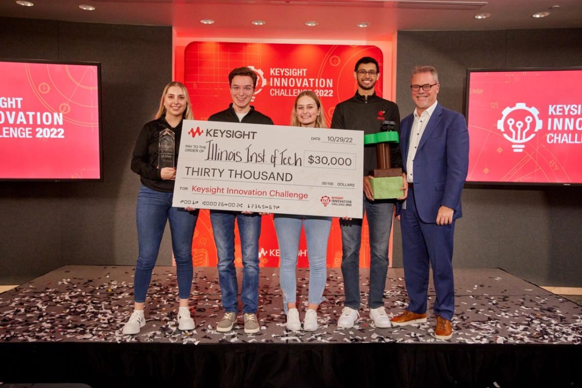 Keysight Chief Customer Officer and Senior Vice President of Global Sales Mark Wallace (right), presents a check to members of the winning Illinois Institute of Technology team (from left), Chloe Rubinowicz, Colin Prochnow, Katarzyna Staron, and Saurabh Saluja.