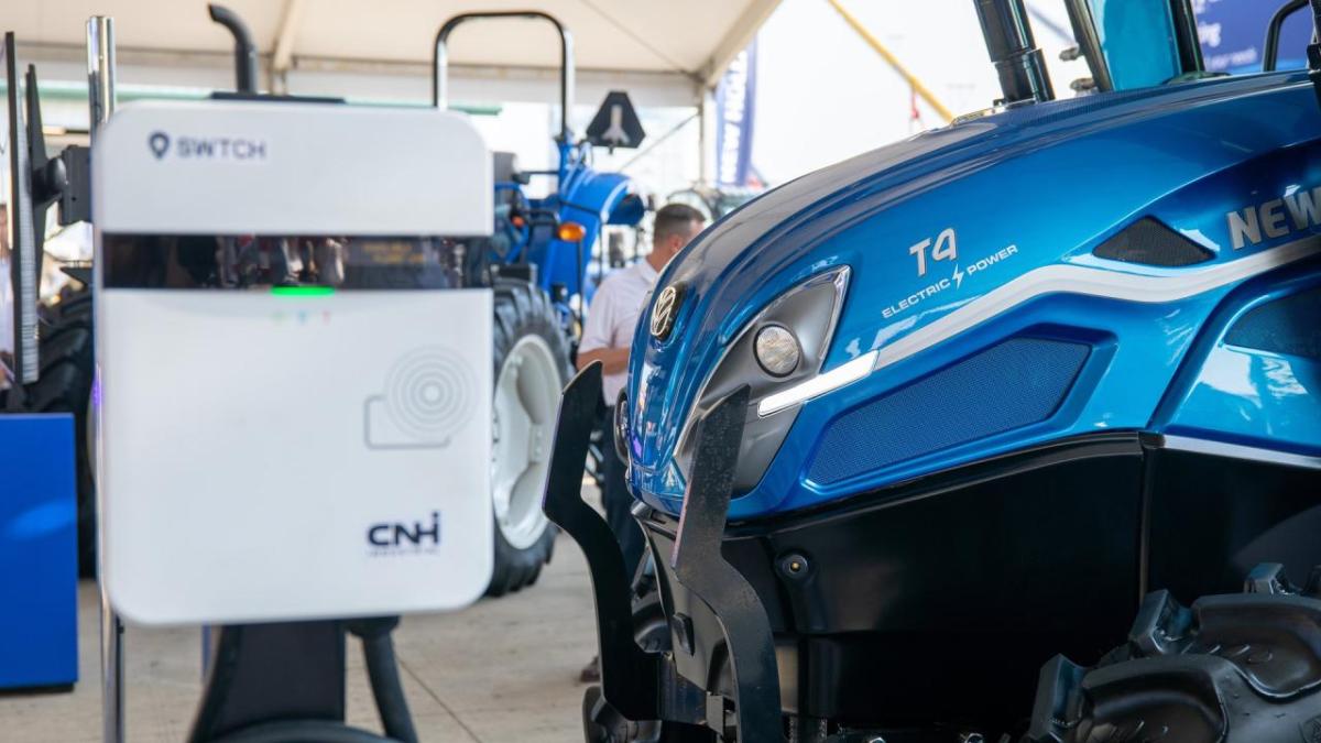 The buzz at the New Holland booth at the 2023 Farm Progress Show was electric. Literally and figuratively. Blue tractor near an electric charger