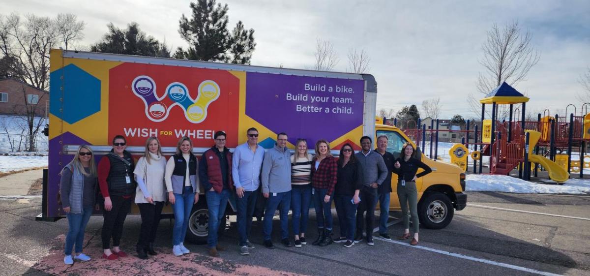 Arrow employees pose in front of a Wish for Wheels truck