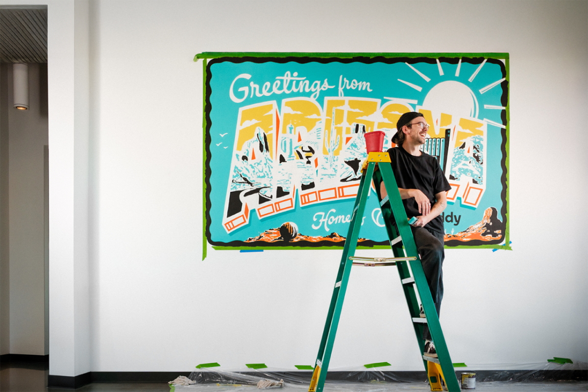 person smiling while standing on a short ladder
