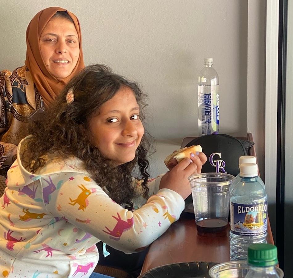 A girl and her mom enjoying a hotdog at the Rockies Opening Day