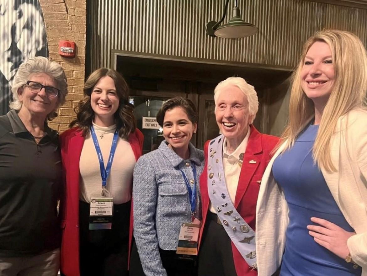 5 people with Daisy (center) at the 2022 WAI conference.