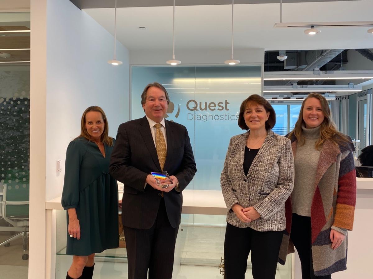 Pictured from left to right: Catherine Milone, President, Junior Achievement of New Jersey; Steve Rusckowski, Chairman, CEO and President, Quest Diagnostics; Gabrielle Wolfson, SVP, Chief Information & Digital Officer, Quest Diagnostics; Krysti Peitz, Manager of Development & Communications, Junior Achievement of New Jersey 4 people standing in front of Quest Diagnostics logo