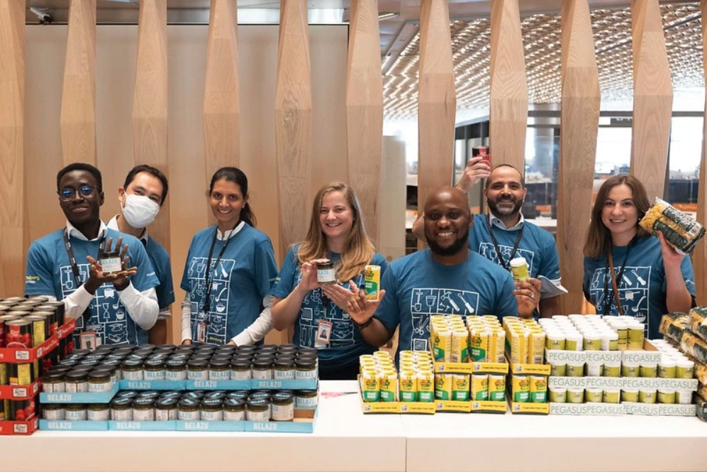 Group holding cans and smiling