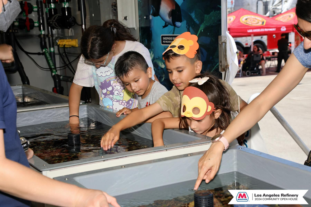 Kids reaching their hands into a touch pool aquarium