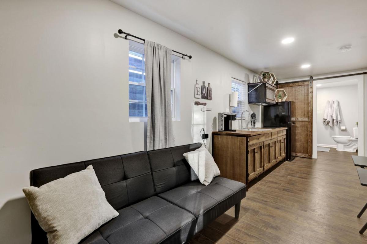 Living room with couch, kitchen and bathroom visible