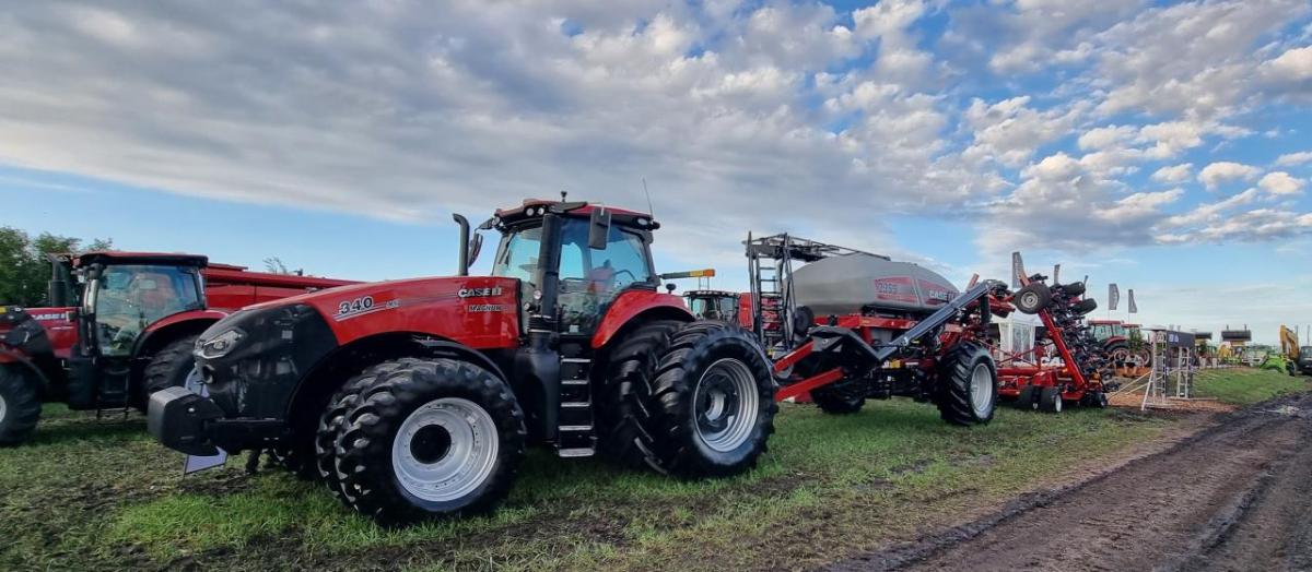 Tractors and equipment in a field under a cloudy sky