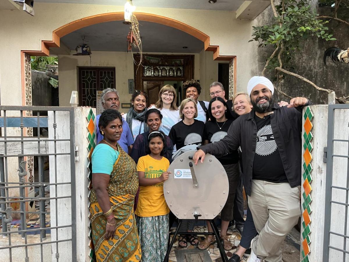 a group of people standing with a dishwasher