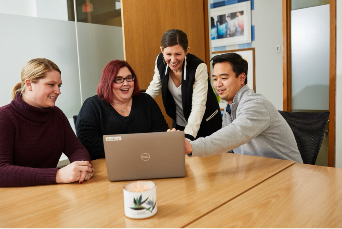 People working at a laptop together at a conference table