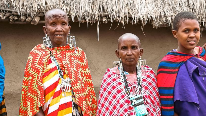 Three people stood next to each other wearing colourful clothing 