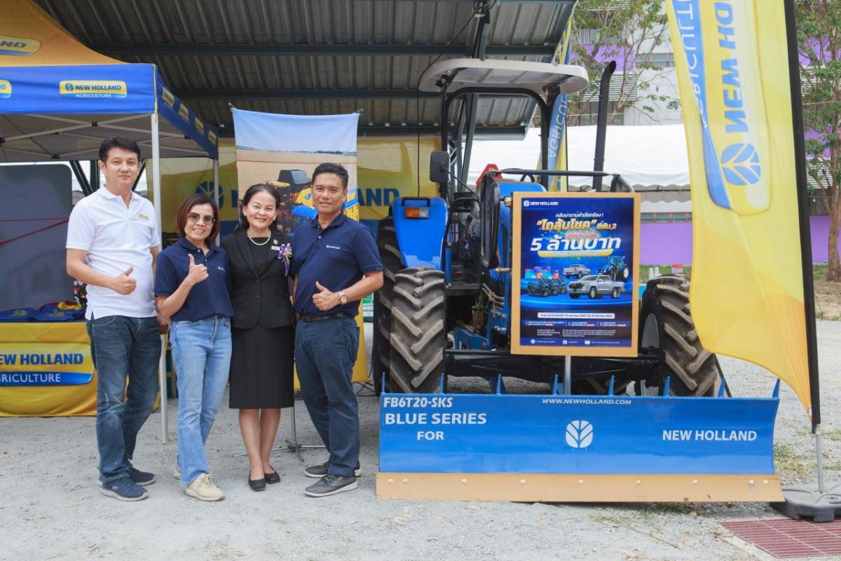 four people standing next to a tractor