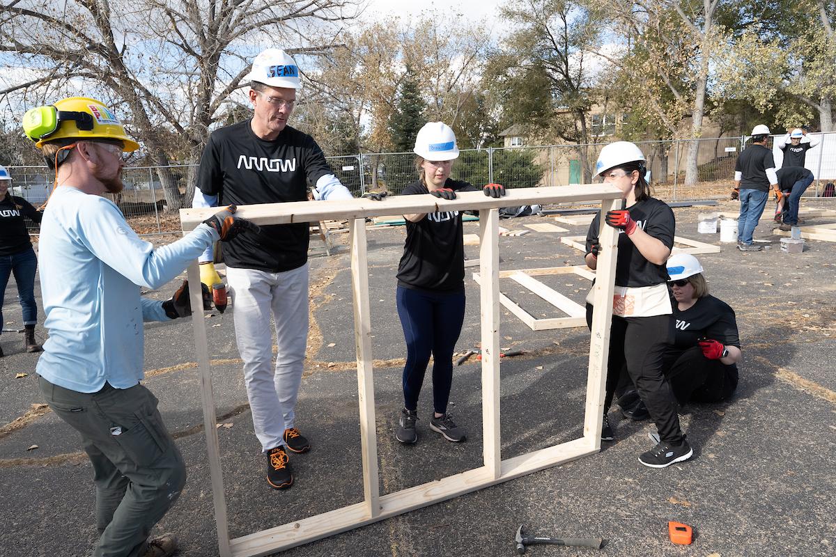 4 arrow employees put a frame together