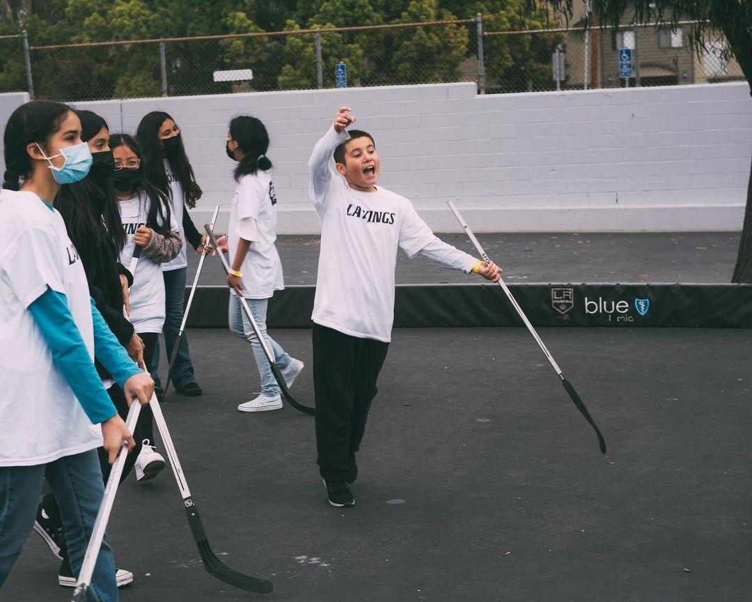 Students have fun participating in a ball hockey clinic following the shoe distribution. 