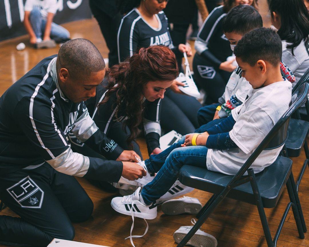 LA Kings Hockey Development Team and LA Kings Ice Crew help students put on their new shoes.