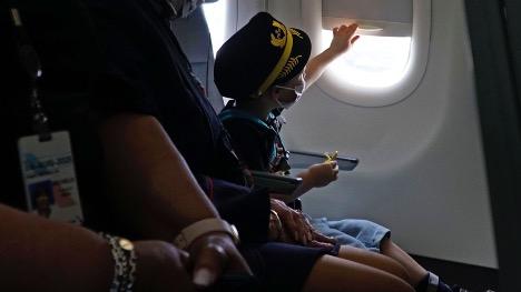 Three-year-old Kanin Nightingale looked out the window on a plane at DFW International Airport on April 2, 2022, during a special practice run conducted by American Airlines to help special needs children and their families get adjusted to air travel. (Lawrence Jenkins / Special Contributor) Courtesy of The Dallas Morning News Child looking out of an airplane window