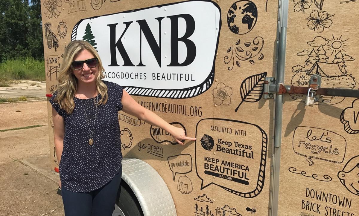 Christine Chute Canul, former Keep Texas Beautiful (KTB) Program Director, points to the KTB and Keep America Beautiful logos on the new Keep Nacogdoches Beautiful e-cycling trailer.