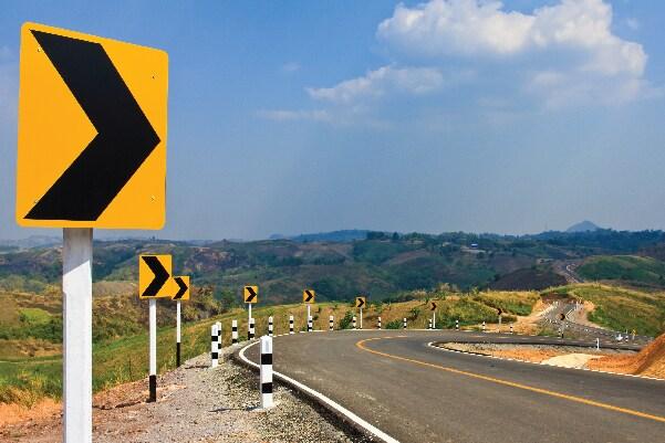 Open road with yellow arrow signs pointing the way.