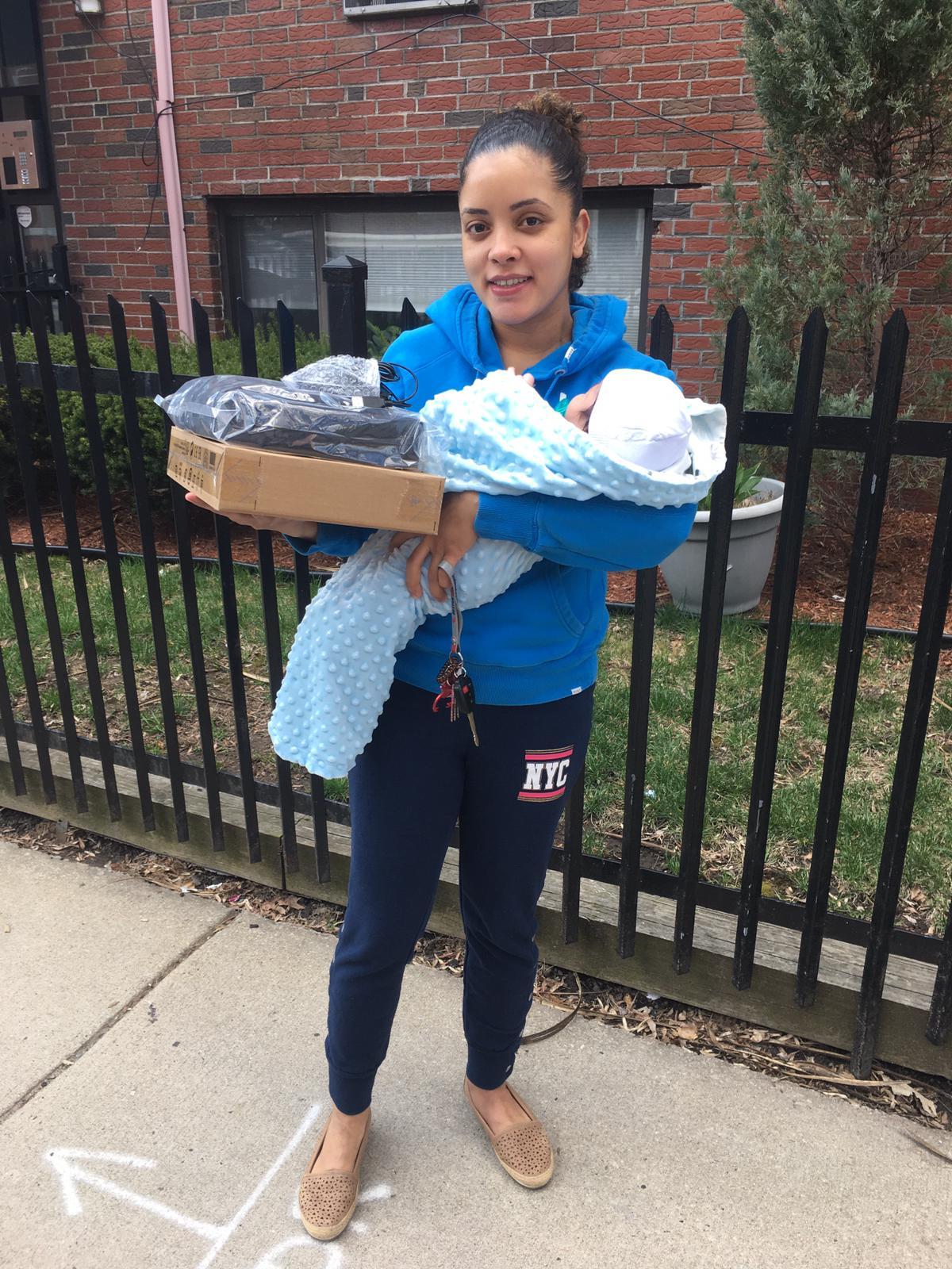 Person holding baby and computer box