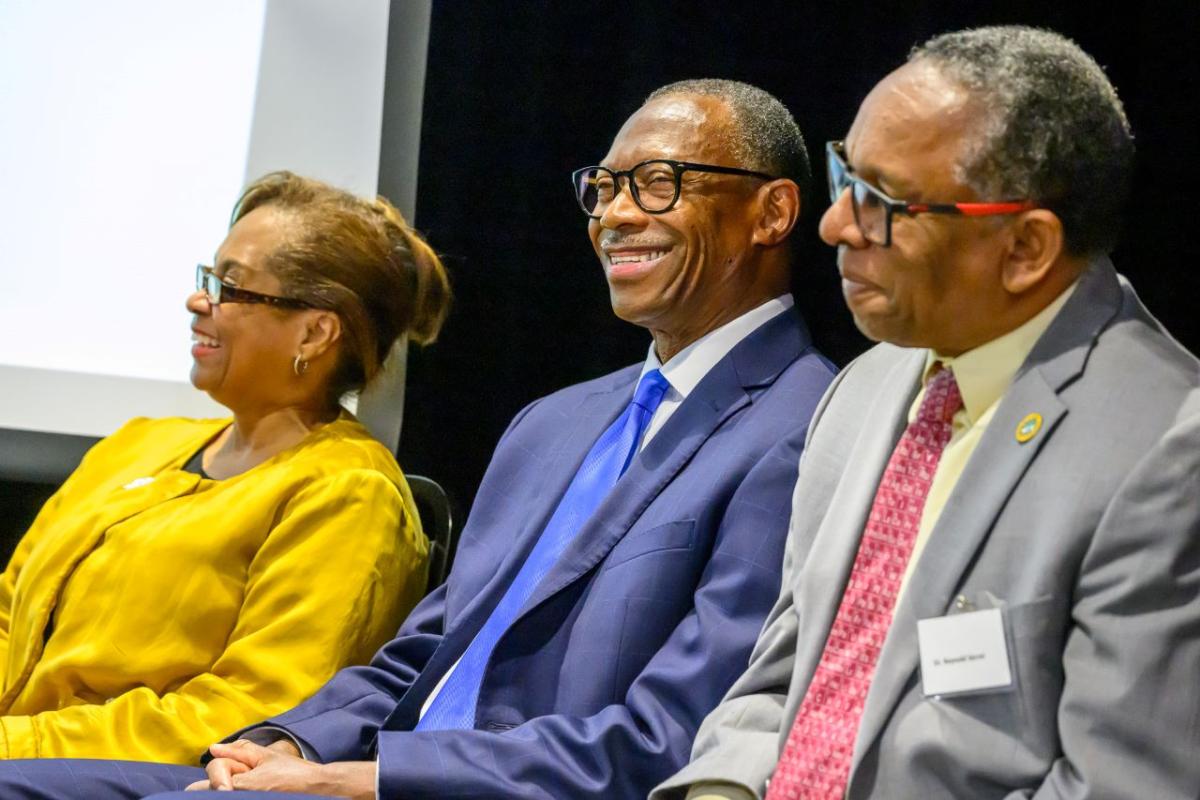 Three people sitting together and smiling