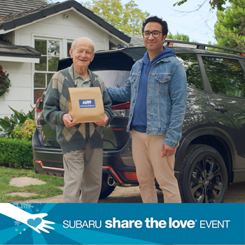 Two people standing by a car in front of a house