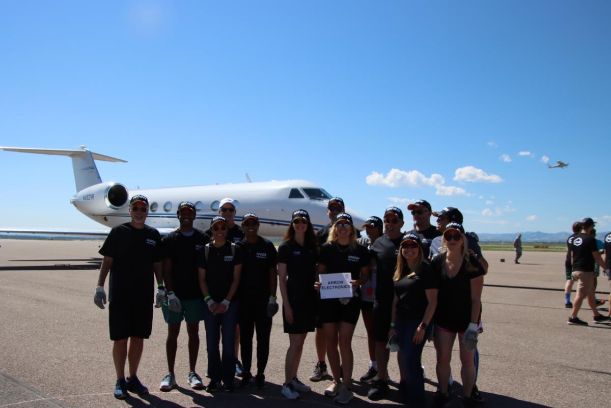 group photo of Arrow employees with the plane in the background