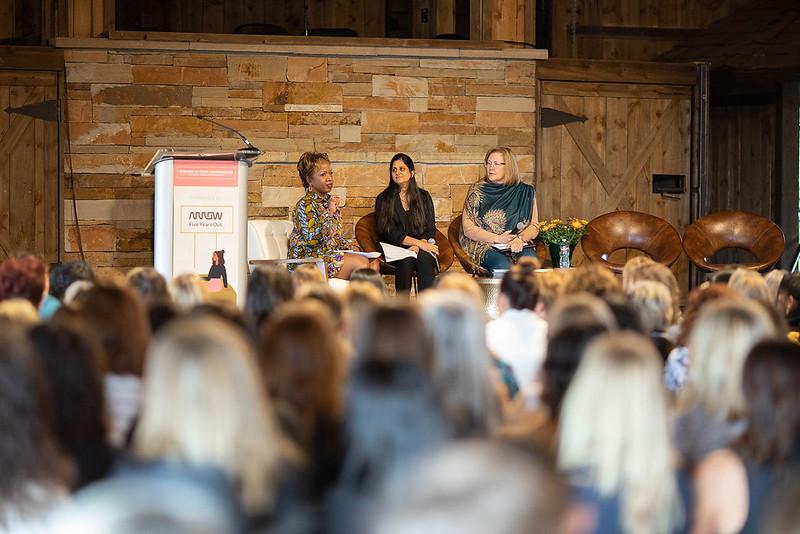 three panelists sit on stage