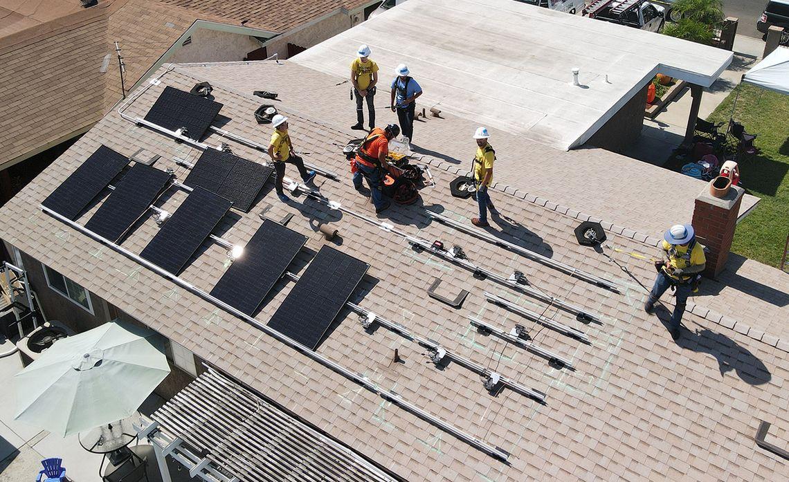 Birdseye view of Edison volunteers installing solar panels on a roof