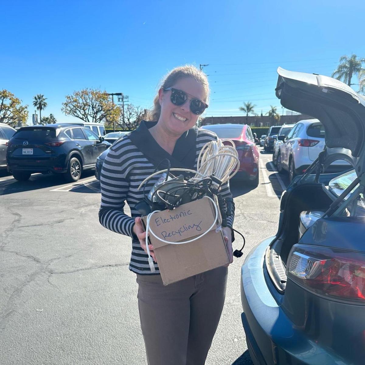 Woman holding box of recycled electronics