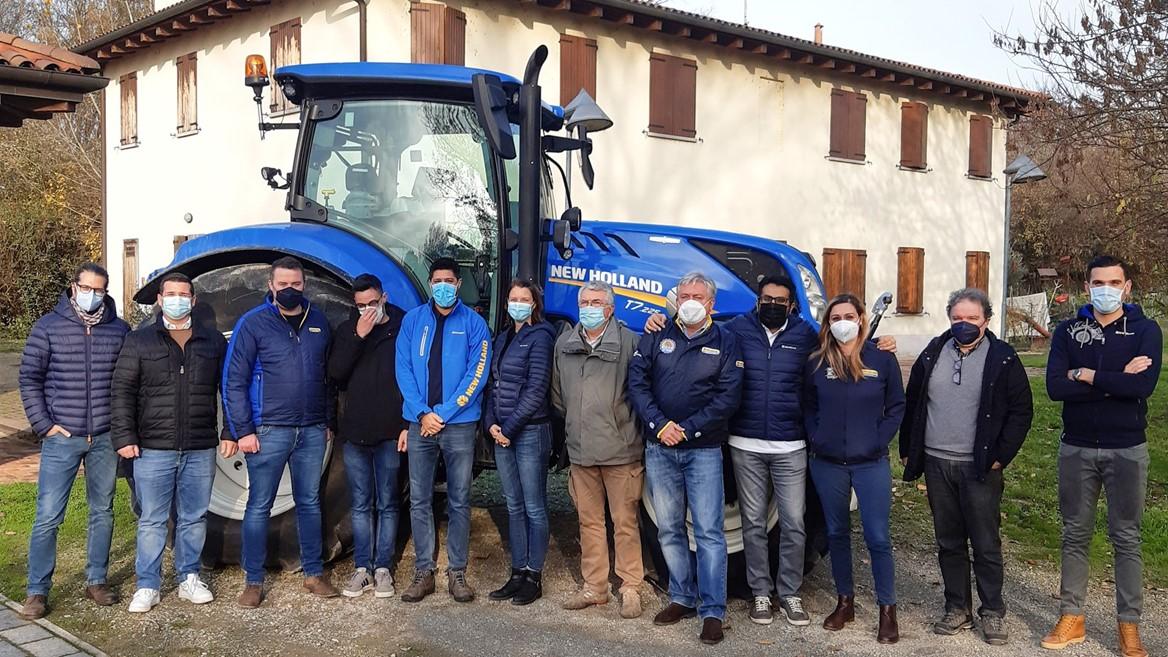 New Holland team in front of blue tractor