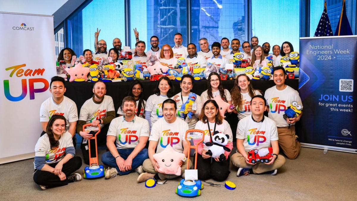 A large group of volunteers holding modified toys 