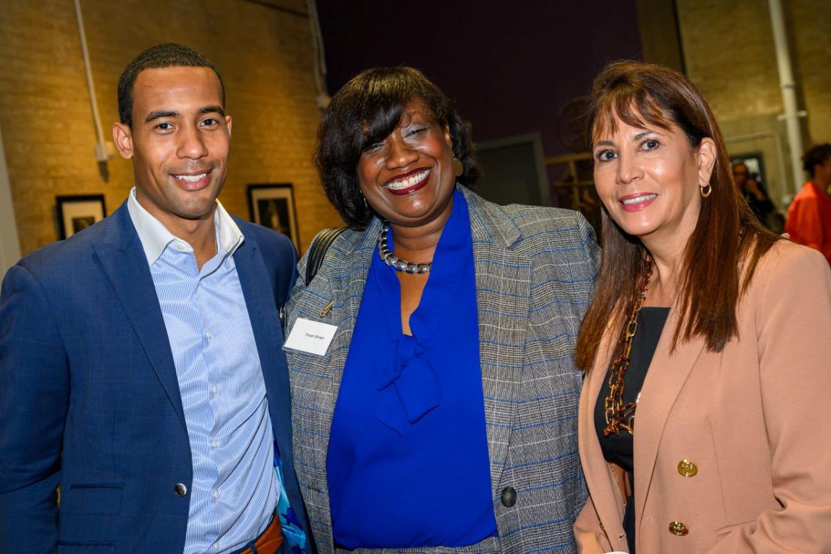 Three people standing together and smiling