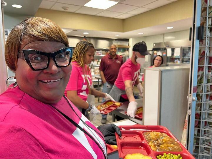 Person smiling with a tray of food