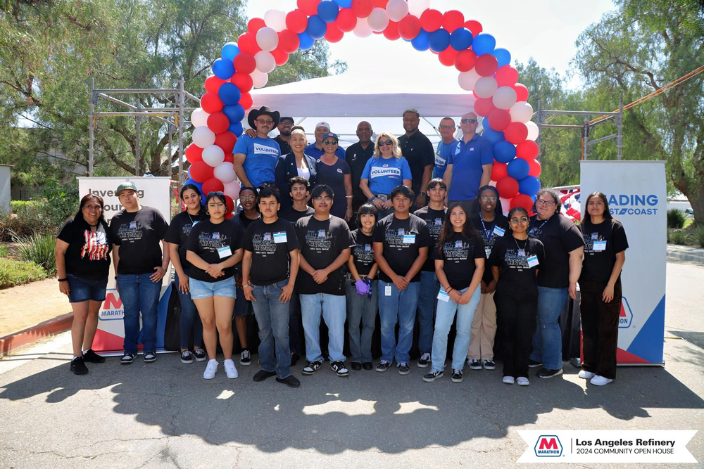 A group posing for the camera underneath a balloon arch