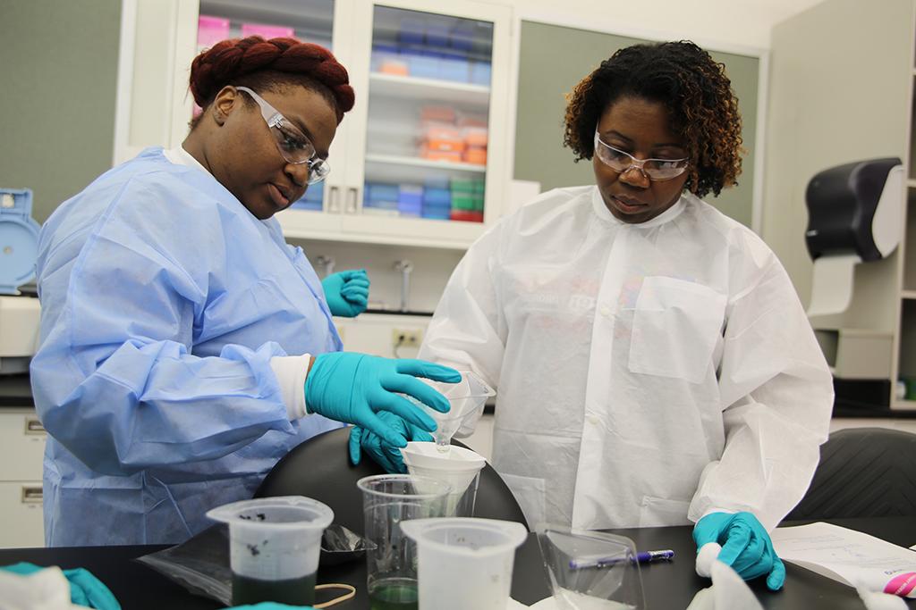 Members of the 2018 STEM TQ cohort perform a water filtration demonstration during a hands-on lab visit to MilliporeSigma.