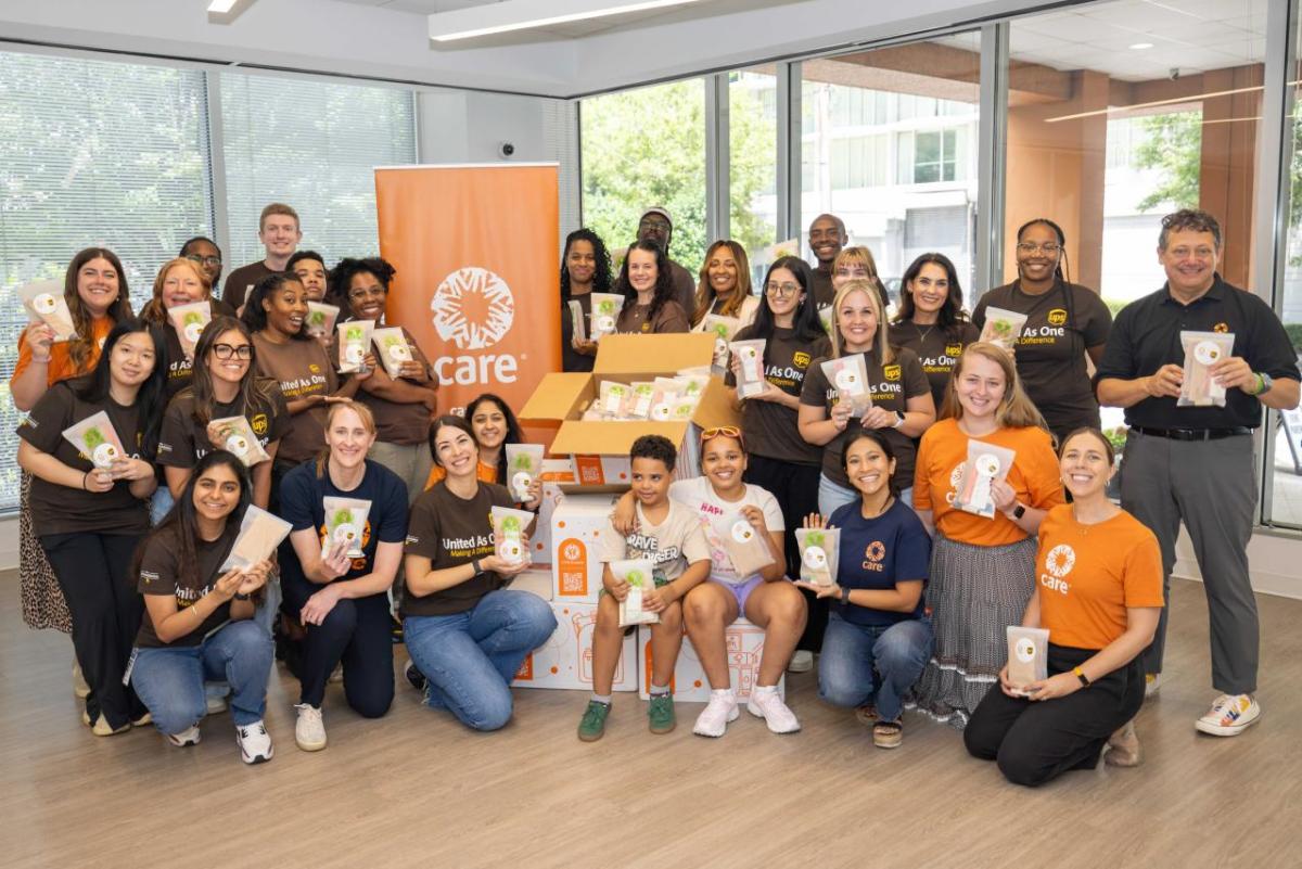 volunteers posing for a group photo with CARE packages