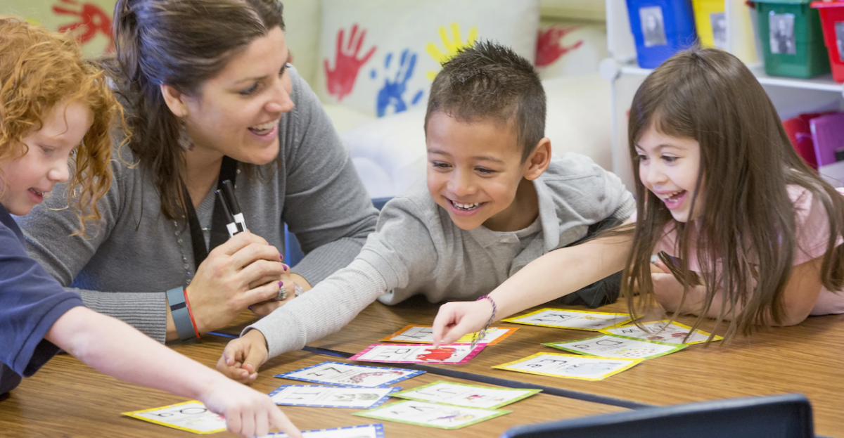 3 children doing a project with a teacher