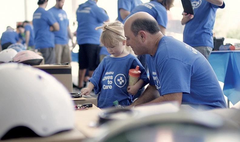 The ad shows retailers, including Rocky DiChristofano of Tucson Subaru, volunteering in their communities.
