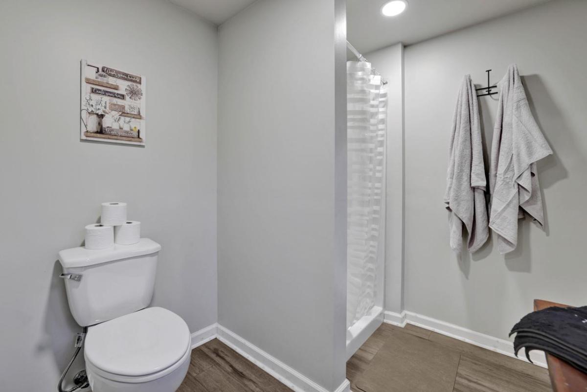 toilet and shower with towels hanging next to it