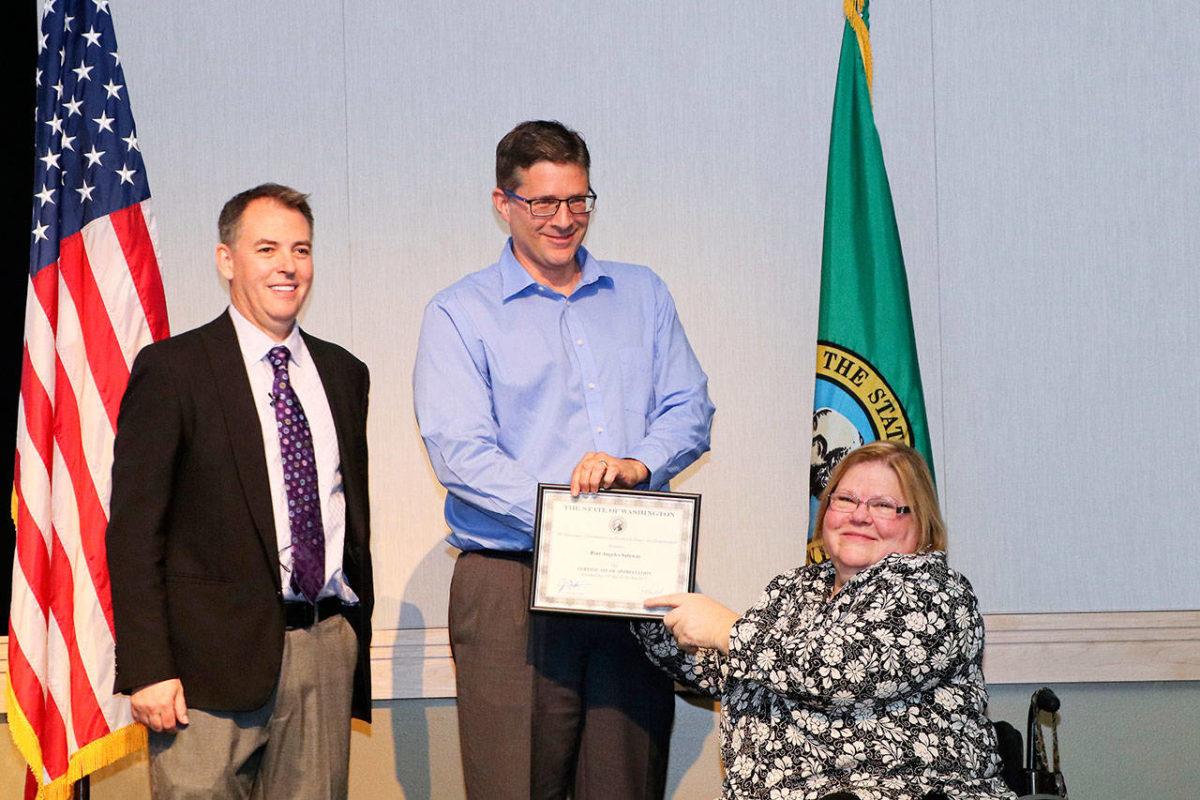 Mike LaGrange, center, who manages the Safeway on Lincoln Street in Port Angeles, receives a certificate for the Governor’s 2017 Medium Private Employer of the Year for the grocery store’s efforts to hire people with disabilities.