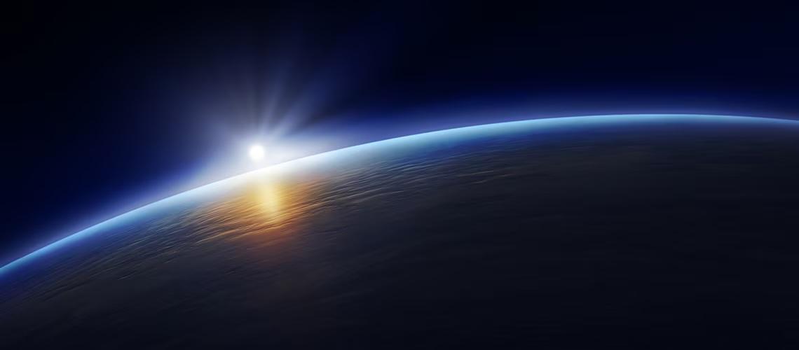 Earth viewed from space, with sun shining behind it