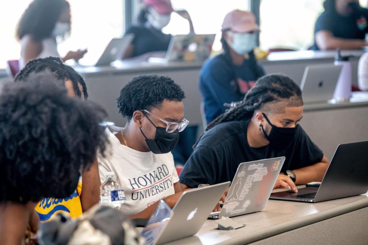 students at long desks each with an open laptop