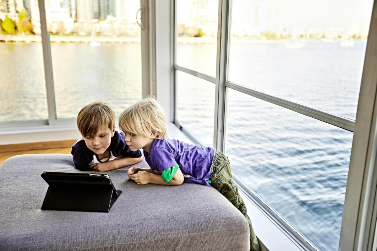 Two children leaning over a laptop computer